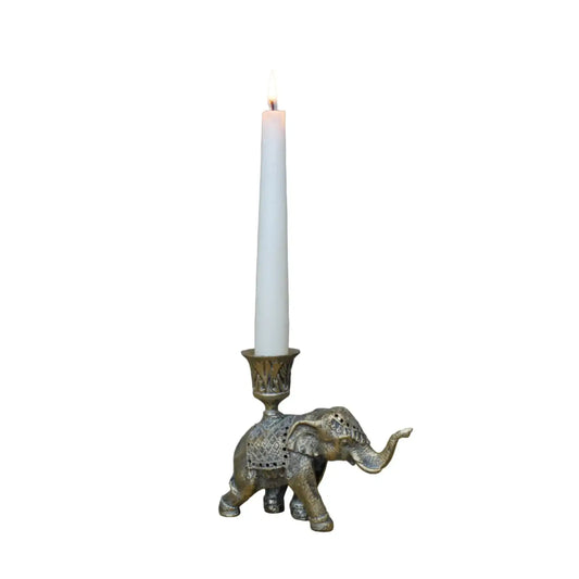 Decorative elephant candle holder with a lit candle on a wooden surface.