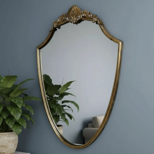 Decorative gold-framed mirror on a floral wallpapered wall