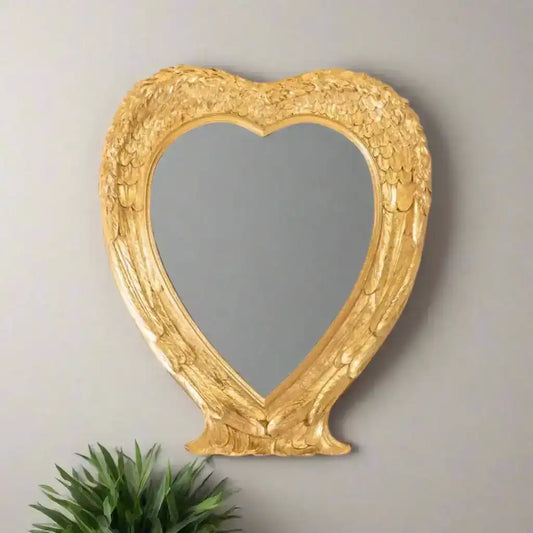Heart-shaped mirror with gold decorative frame on a white background