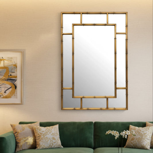 Gold-framed mirror with geometric design on a white background