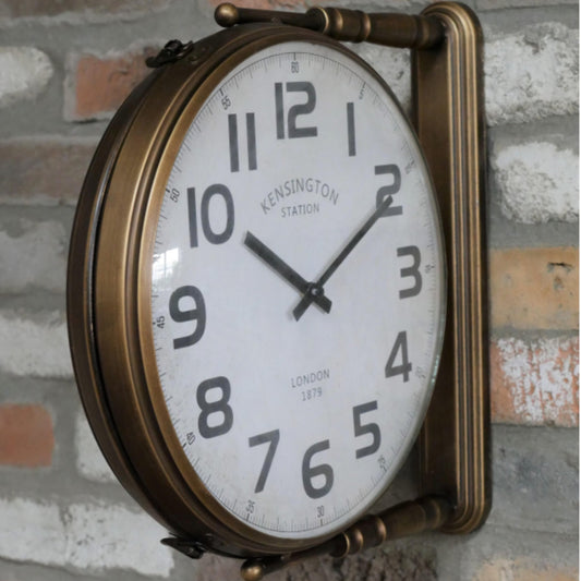 Vintage-style wall clock with brass frame on a brick wall.