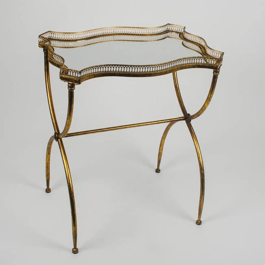 Decorative gold metal table with intricate design on a gray background