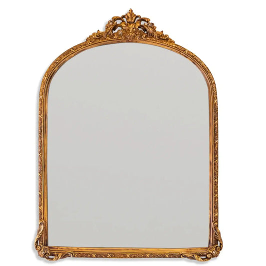 Decorative gold-framed mirror on a white background