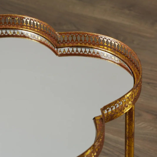 Gold-framed mirror on a wooden surface
