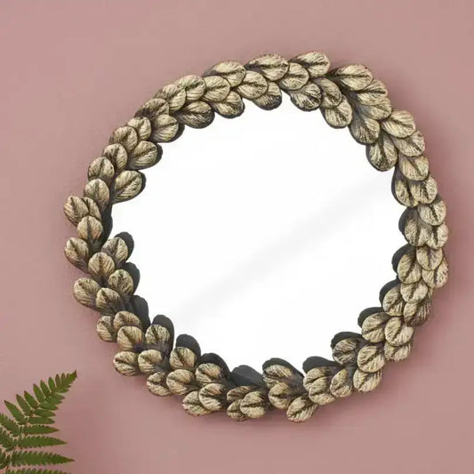 Decorative mirror with leaf-like frame on a white background