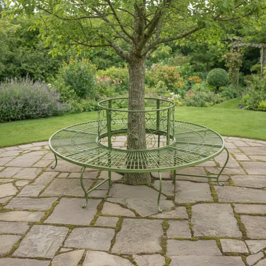 Round metal garden seat wrapped around a tree in a lush garden setting