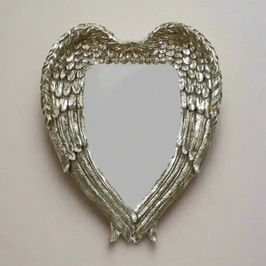 Heart-shaped mirror with angel wings on a white background