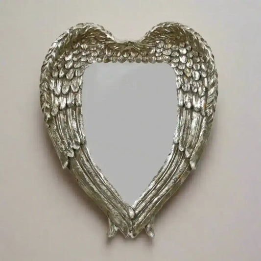 Heart-shaped mirror with angel wings on a white background