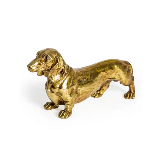 Gold-colored dachshund figurine on a white background