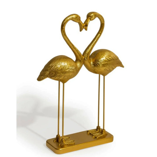 Gold flamingo sculpture forming a heart shape on a white background
