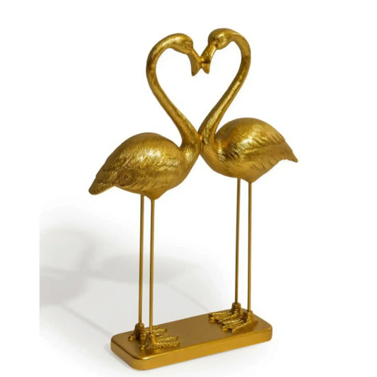Gold flamingo sculpture forming a heart shape on a white background