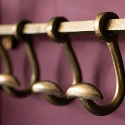 Close-up of a set of brass hooks on a purple background