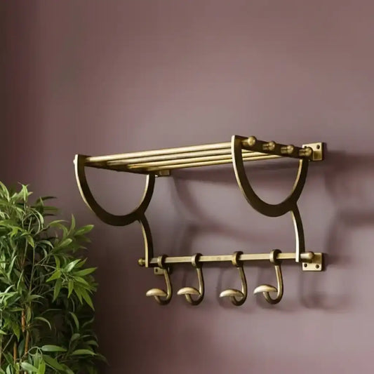 Brass towel rack with hooks on a purple wall