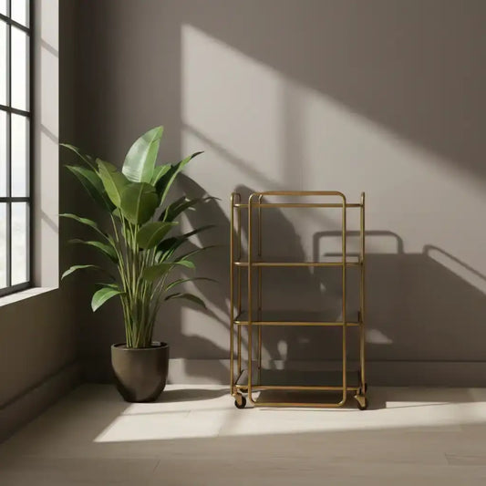 Gold metal bar cart next to a potted plant in a sunlit room