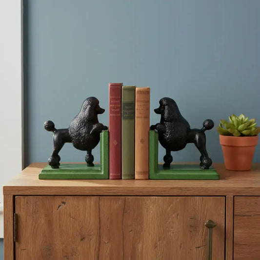 Black poodle-shaped bookends on a wooden cabinet with books and a plant.