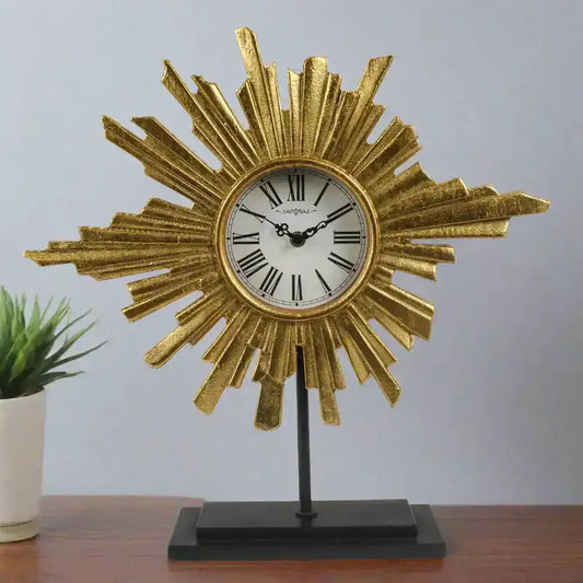 Decorative clock with sunburst design on a stand against a gray background