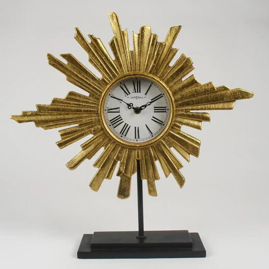 Decorative clock with sunburst design on a stand against a gray background