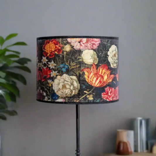 Floral-patterned lampshade on a stand against a neutral wall.