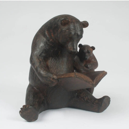Bronze statue of a bear holding a cub on a white background