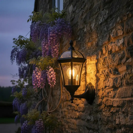 Black outdoor wall light fixture on a textured wall with a blurred background
