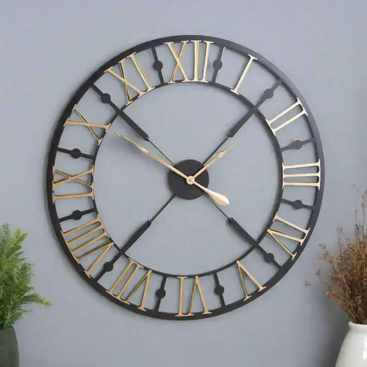 Large round wall clock with black and gold details on a white background