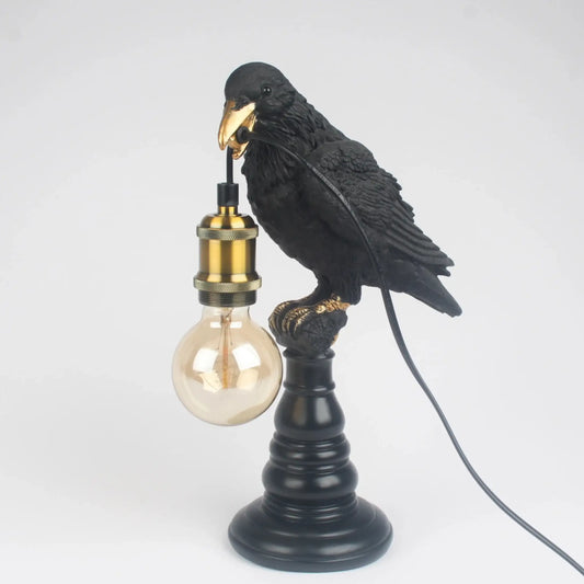 Black bird-shaped lamp with a light bulb on a white background