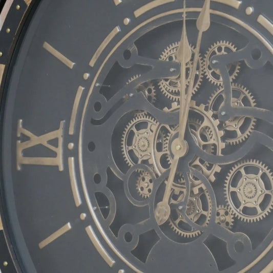 Close-up of a mechanical clock face with gears and Roman numerals.