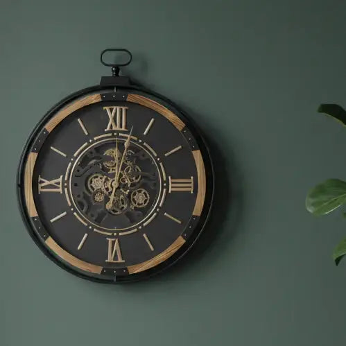 Decorative wall clock with Roman numerals on a green wall