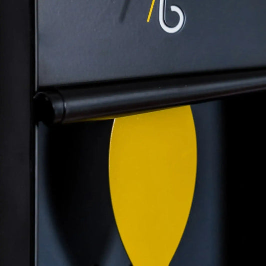 Close-up of a black surface with a yellow leaf-shaped object and a logo in the corner.