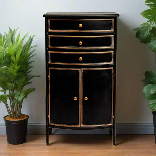 Black cabinet with gold accents on a wooden floor with plants