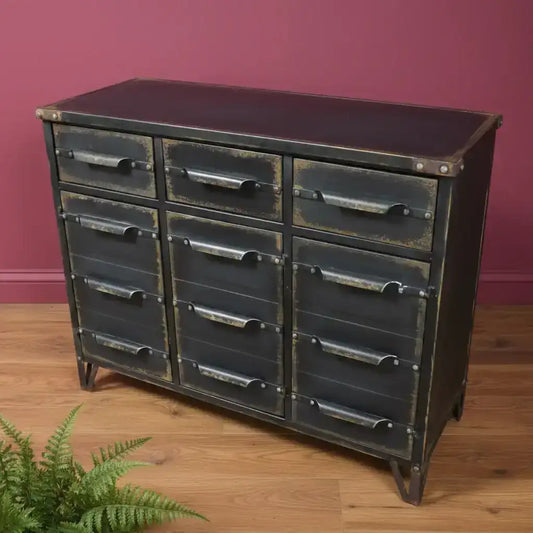 Industrial-style metal dresser with multiple drawers against a brick wall.