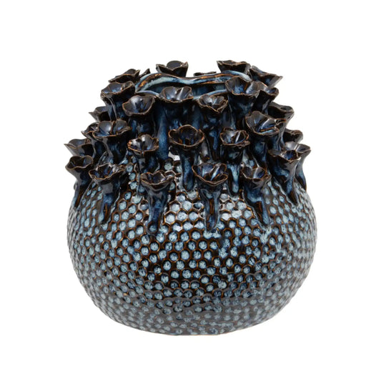 Decorative ceramic vase with textured surface and floral-like top on a white background