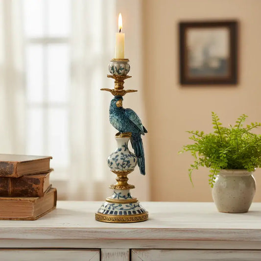 Decorative candlestick with a bird design on a table next to books and a plant.