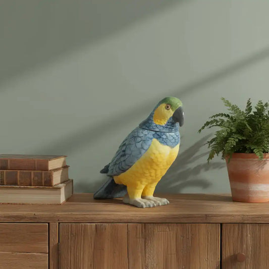 Decorative parrot sculpture on a wooden surface with books and a plant.