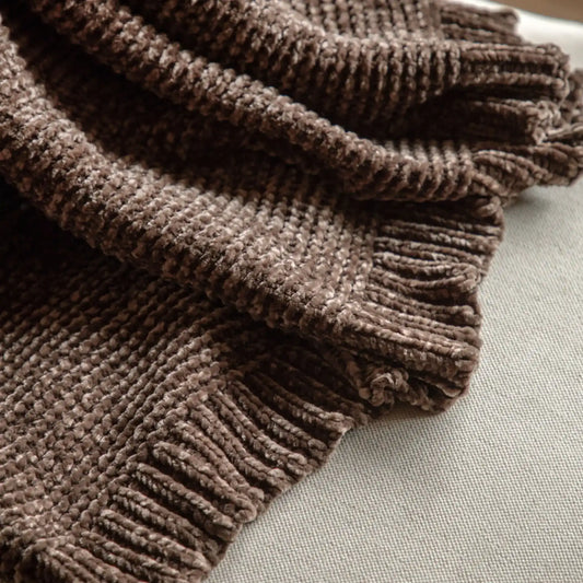 Brown textured blanket on a light gray surface