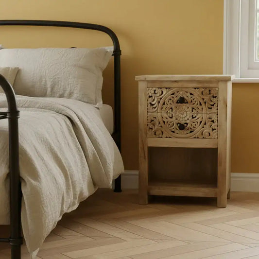 Bedroom with a bed and wooden nightstand against a yellow wall.