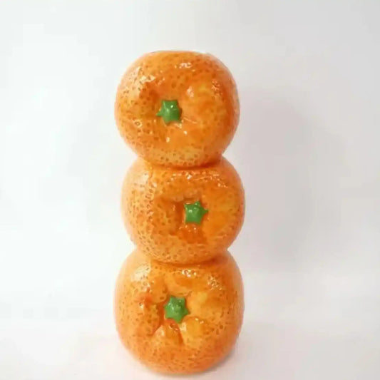Three stacked oranges with green stems on a white background