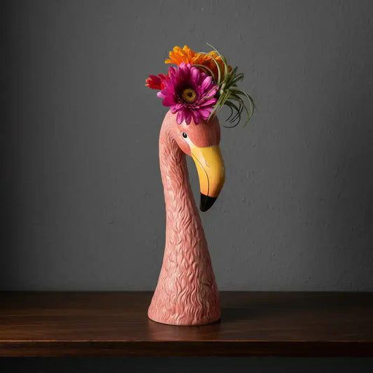 Flamingo figurine with a floral headpiece on a white background