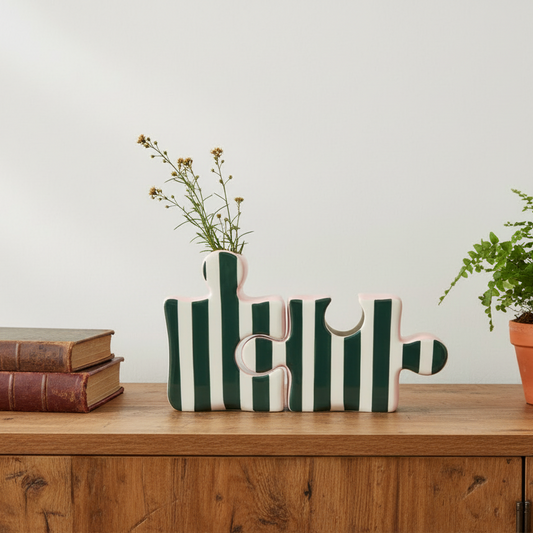 Decorative items including books, a vase with plants, and a striped letter 'E' on a wooden surface.