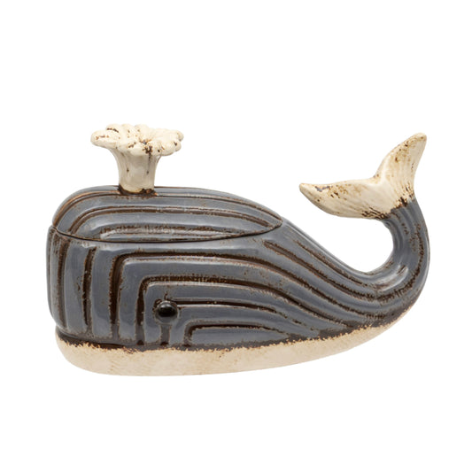 A whale-shaped ceramic container with a lid, featuring a dark brown and beige striped pattern with a cream-colored blowhole and tail.
