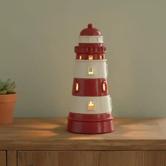 Red and white lighthouse-shaped lamp on a wooden surface with a plant in the background.