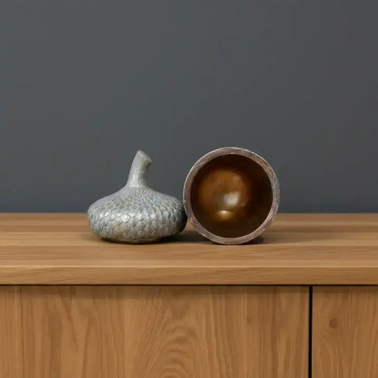 Decorative ceramic jar with textured lid on a wooden surface