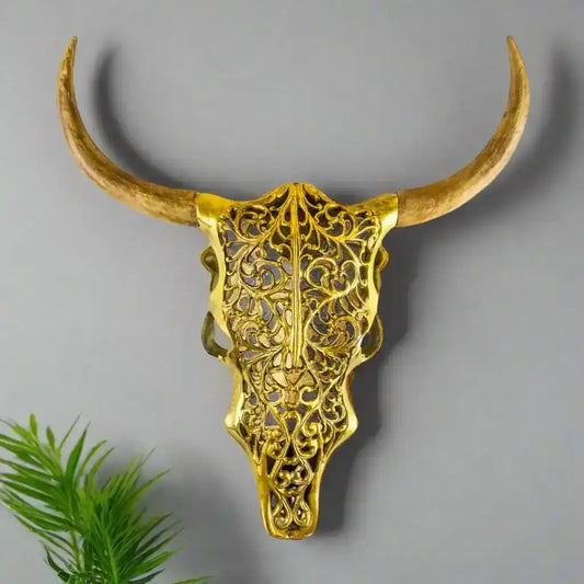 Decorative gold bull skull with long horns on a white background