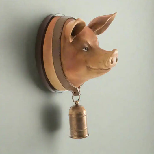 Pig head wall decoration with a bell on a white background