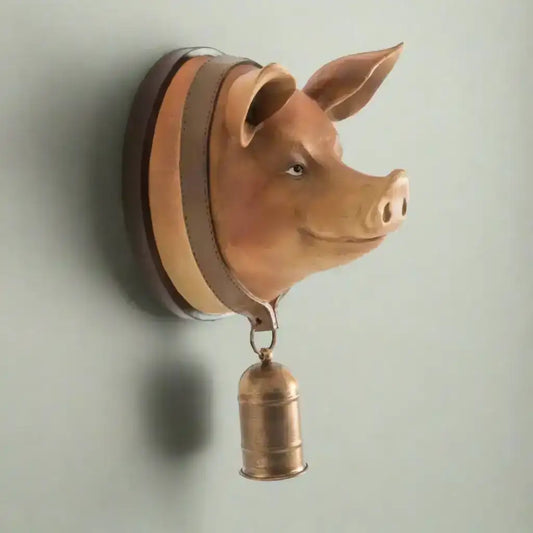 Pig head wall decoration with a bell on a white background