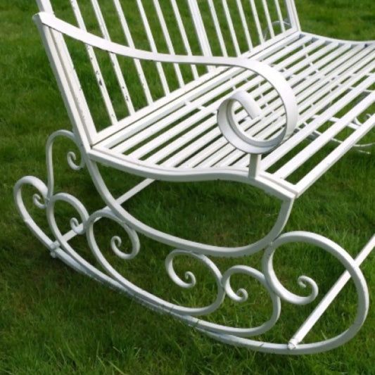 White metal rocking chair on a grassy background