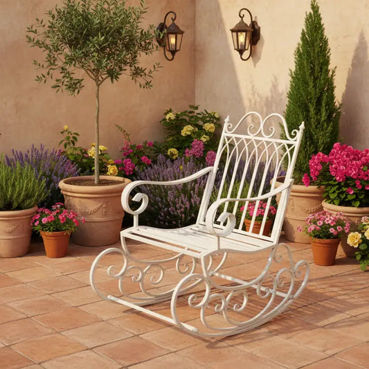 White ornate rocking chair on a patio with potted plants and flowers.