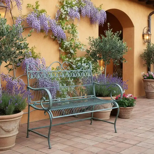 Decorative metal garden bench on a paved patio with greenery in the background