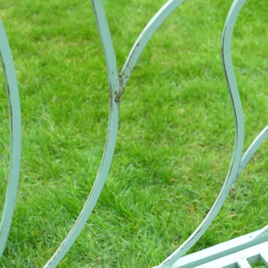 Metal garden chair with peeling paint on a grassy background