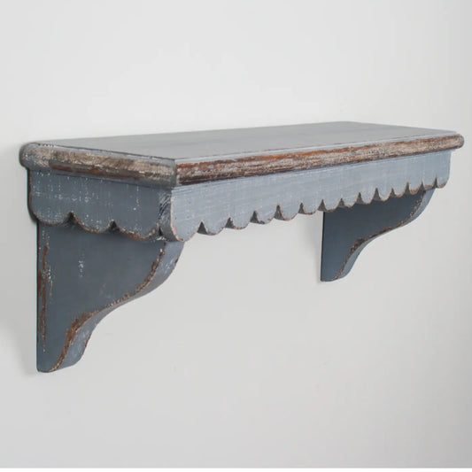 Worn wooden shelf with scalloped edge on a light gray background
